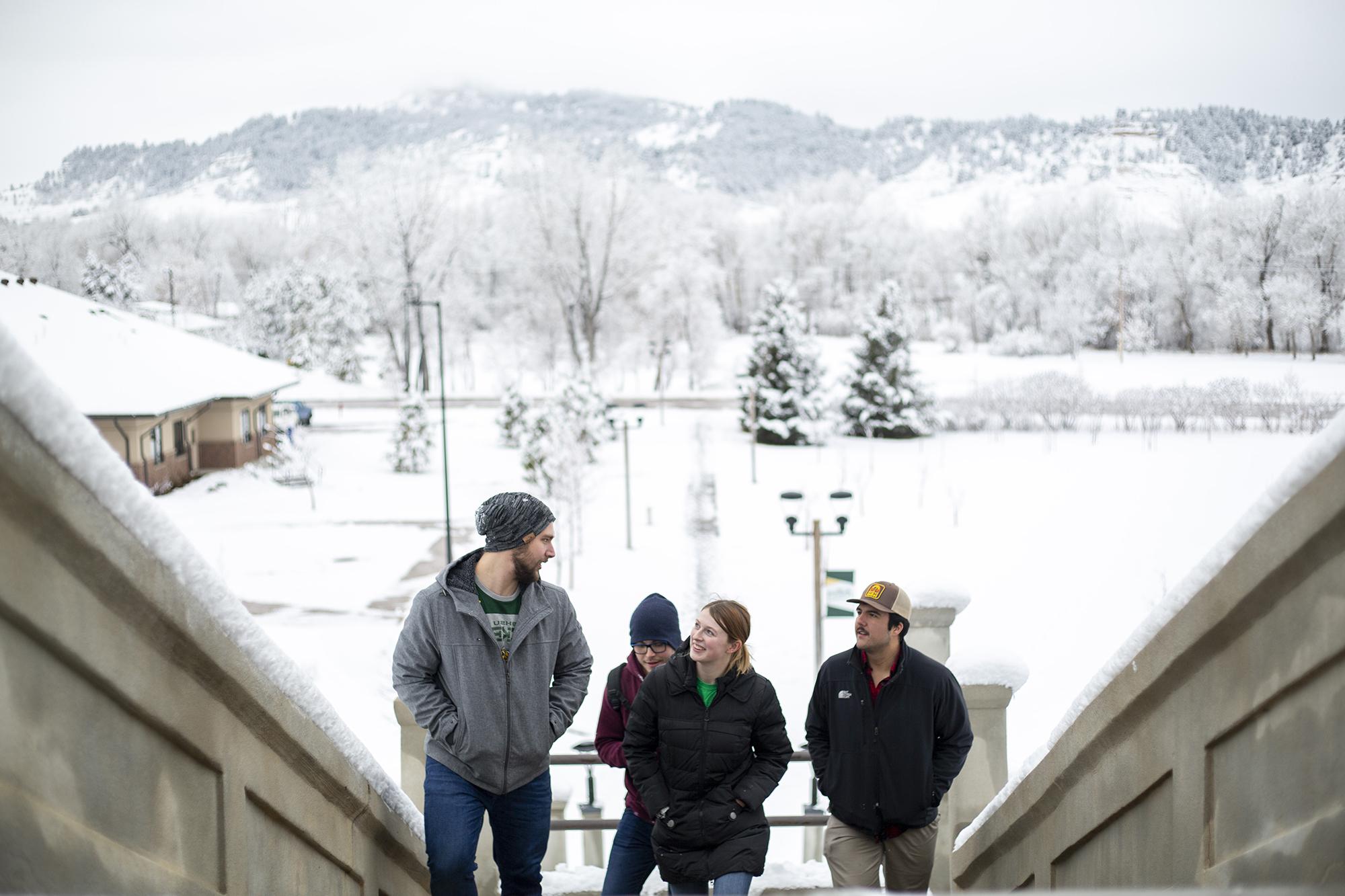 Four students explore campus in the snow.